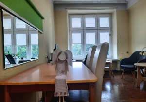 Gabinet logopedyczny. Biurko z krzesłami, lustro z roletą na ścianie.