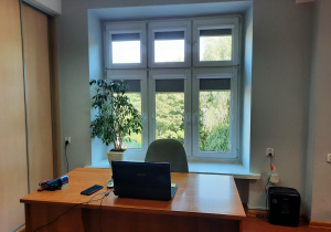 Sekretariat, pokój 208, piętro drugie. Biurko z krzesłem i komputerem, za nim okno.